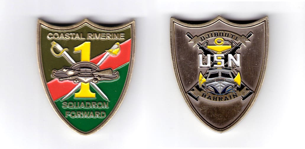 Shield shaped coin, antique brass in color, 2 inches high x 1 5/8 inches wide.