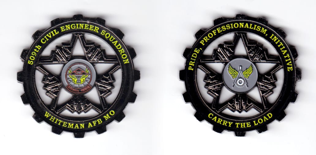 Cogwheel shaped coin, black enamal in color, 2 inches in diameter.