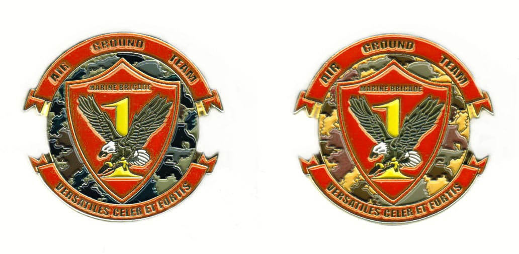 Round shaped coin with ribbon banners above and below, brass in color, 1 7/16 inches high x 1 1/2 inches wide.