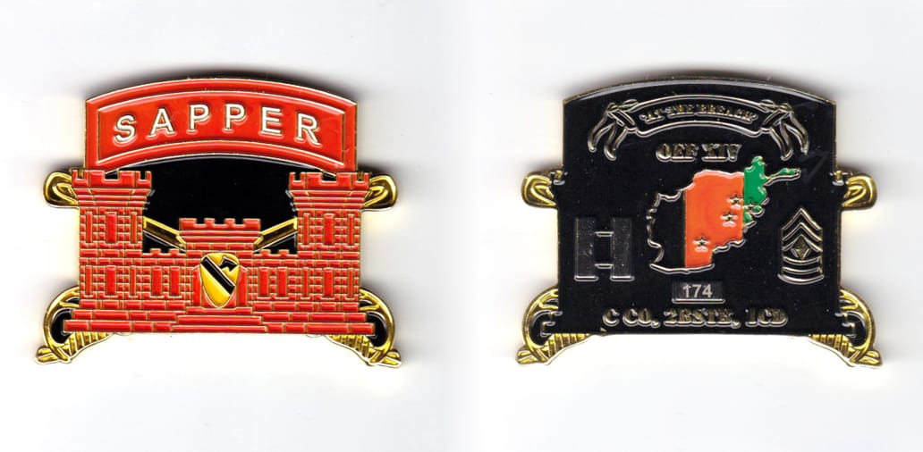 Engineer castle shaped coin with arched banner over and crossed sabers behind, brass in color, 1 1/2 inches high x 2 inc...