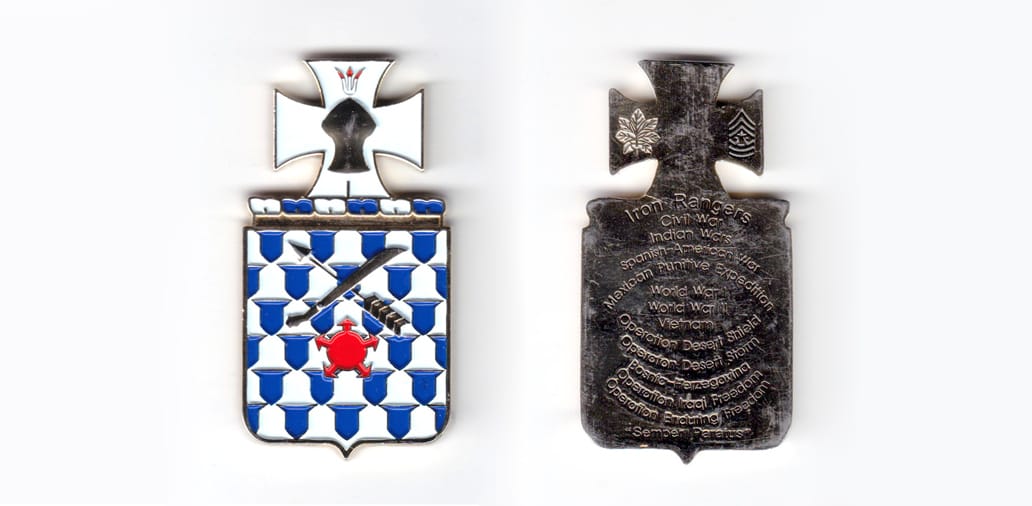 Modern French shield shaped coin topped by twisted blue and white yarn and a Maltese cross.