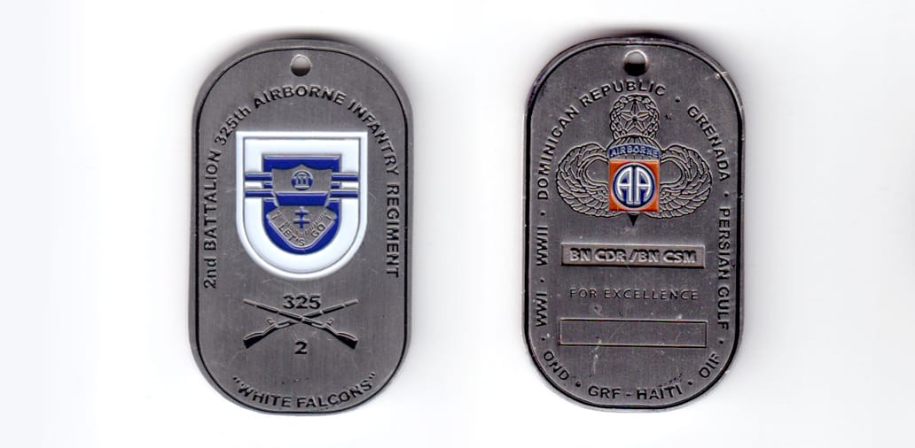 Dog tag shaped coin, pewter in color, 2 inches high x 1 1/8th inches wide.