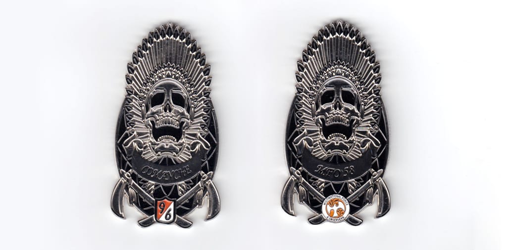 Coin is oval shaped with a skull in Native American Headdress over and extending above and crossed tomahawks above and e...