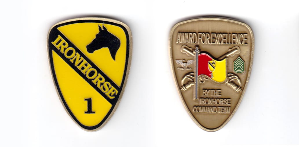 Shield shaped coin, antique brass in color, 2 inches high x 1 1/2 inches wide.