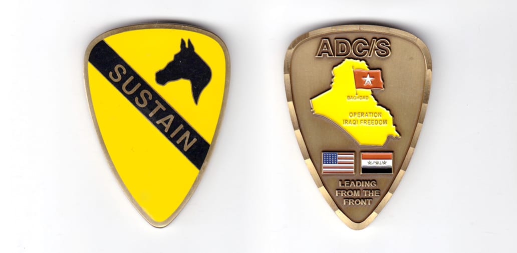 Shield shaped coin, antique brass in color, 2 inches high x 1 1/2 inches wide.