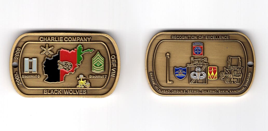 Dog tag shaped coin, antique brass in color, 1 1/4 inches high x 2 1/8 inches wide.