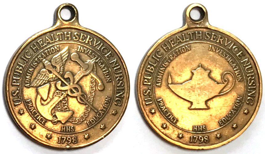 Round shaped medal, 1.8 inches high x 1.5 inches wide, antique brass in color.